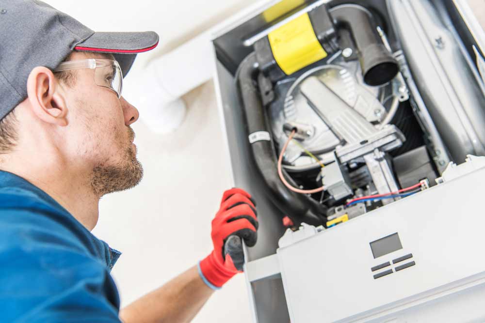 man-fixing-heating-system Heating repairs being performed by a professional in Dallas, TX.