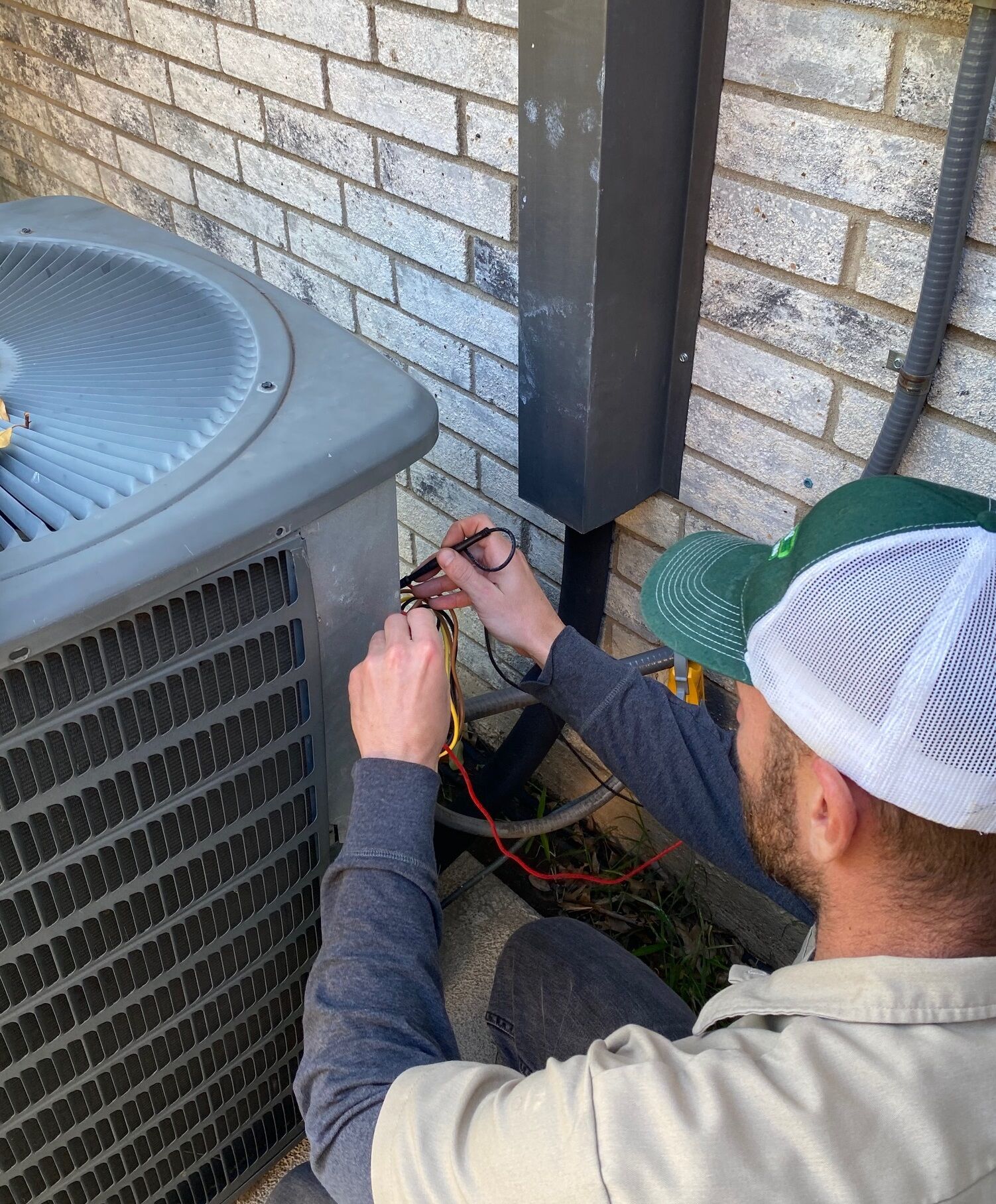 AC REPAIR CAP Washburn Air technician conducting AC repair in Dallas, diagnosing voltage issues.